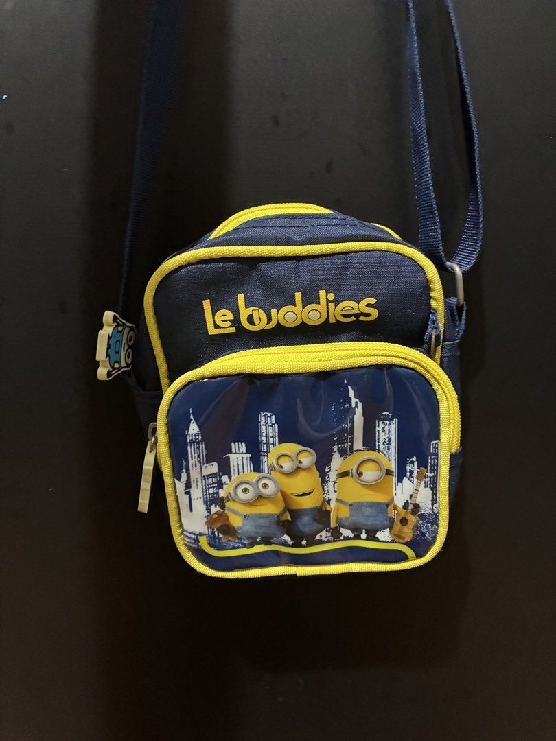 Le Buddies Minions Crossbody Bag (Category: Cross-body Bags) located in Quezon City. Submitted by grai25 (Listing ID 1439676355, Image 1). Description: - Le Buddies Minions Crossbody Bag - Fun Minions design - Main compartment with zipper - Front pocket with zipper - Blue strap - Yellow trim - Features "Le Buddies" text and Minions against a city skyline.