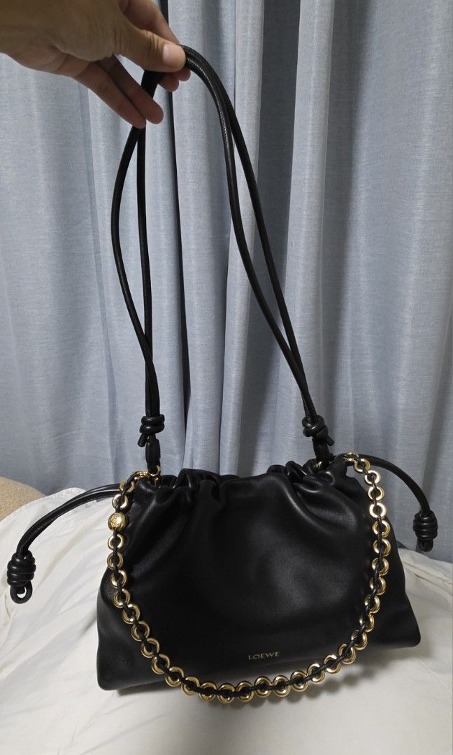 Loewe Flamenco Purse (Category: Luxury Bags & Wallets) located in Cainta. Submitted by annavm (Listing ID 1439609276, Image 1). Description: - Authentic Loewe Flamenco Clutch Bag - Classic black leather - Elegant gold chain detail - Secure drawstring closure - Stylish knotted shoulder straps - Iconic Loewe logo - Luxurious leather construction this is an unused item. with hairline scratch on donut chain with legit grails certificate of authentici