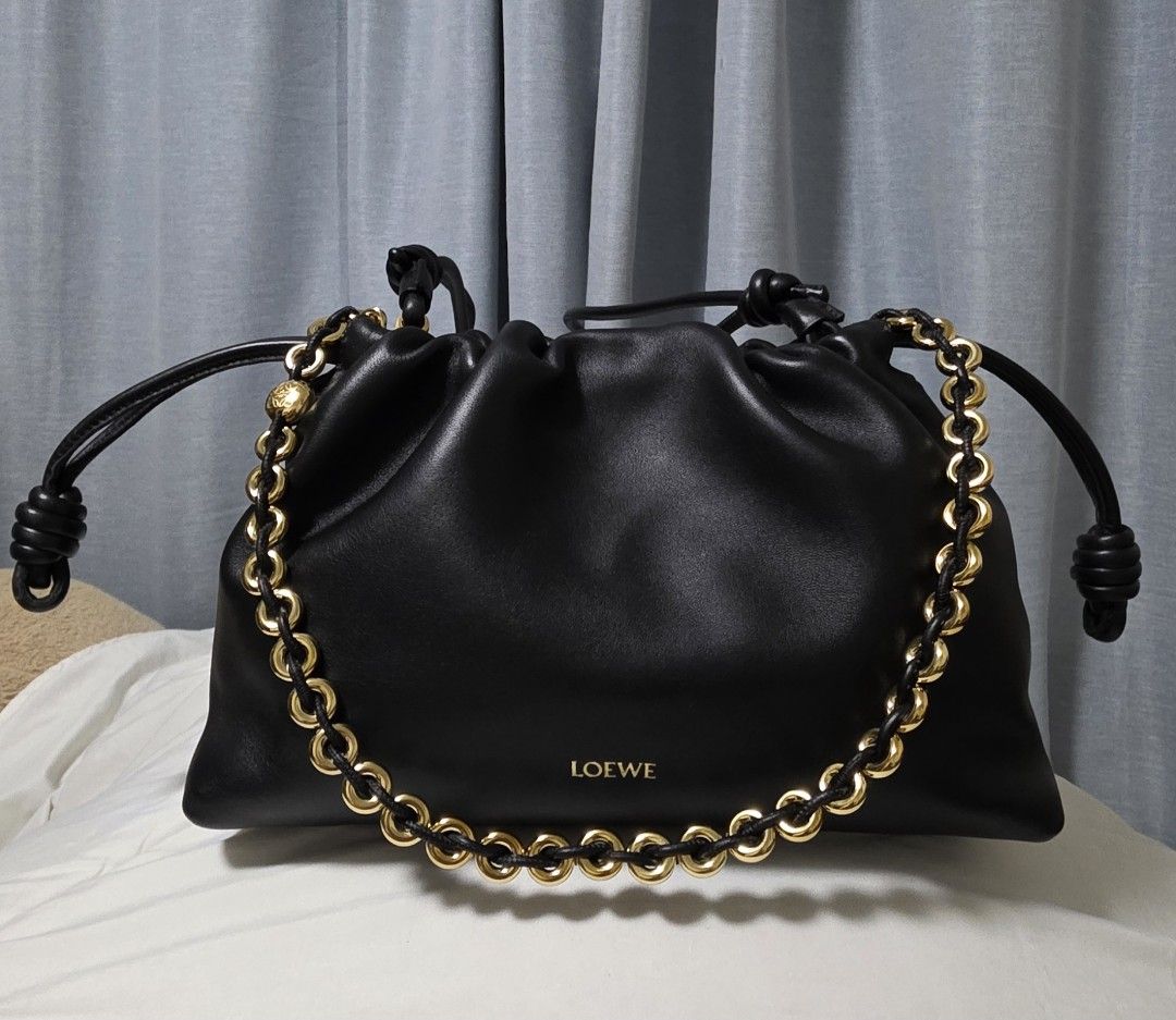 Loewe Flamenco Purse (Category: Luxury Bags & Wallets) located in Cainta. Submitted by annavm (Listing ID 1439609276, Image 2). Description: - Authentic Loewe Flamenco Clutch Bag - Classic black leather - Elegant gold chain detail - Secure drawstring closure - Stylish knotted shoulder straps - Iconic Loewe logo - Luxurious leather construction this is an unused item. with hairline scratch on donut chain with legit grails certificate of authentici