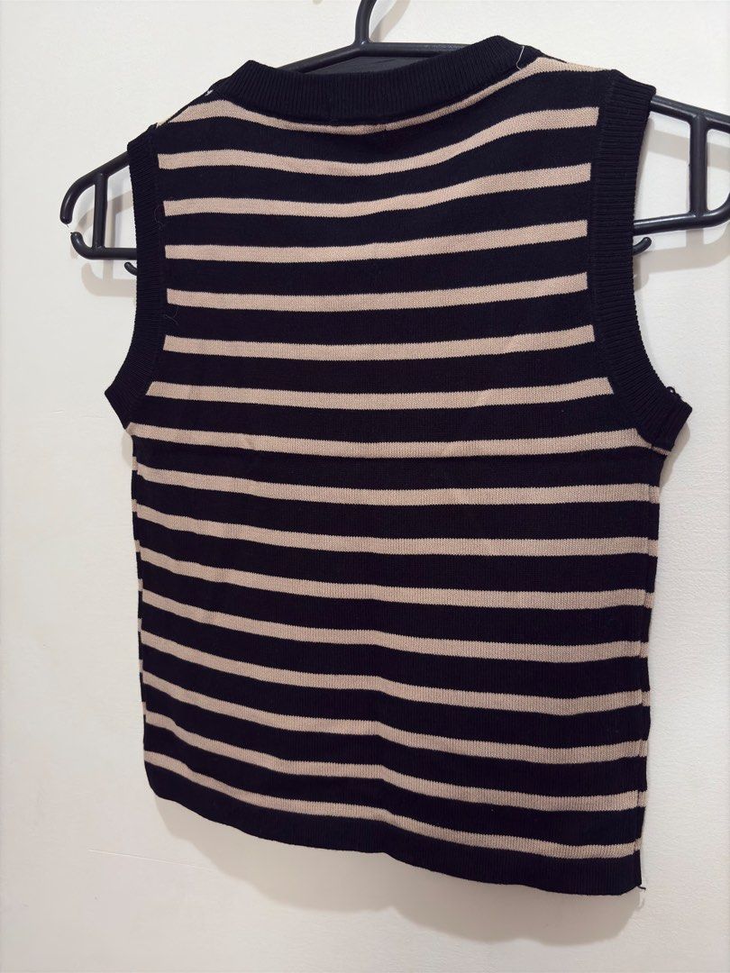 Love Crissa Striped Vest (Category: Sleeveless) located in Quezon City. Submitted by mae_iggy (Listing ID 1439697926, Image 3). Description: - Love Crissa vest - Classic black and beige striped design - Round neckline - Sleeveless - Made of knit material - Size M - Versatile for layering or wearing alone.