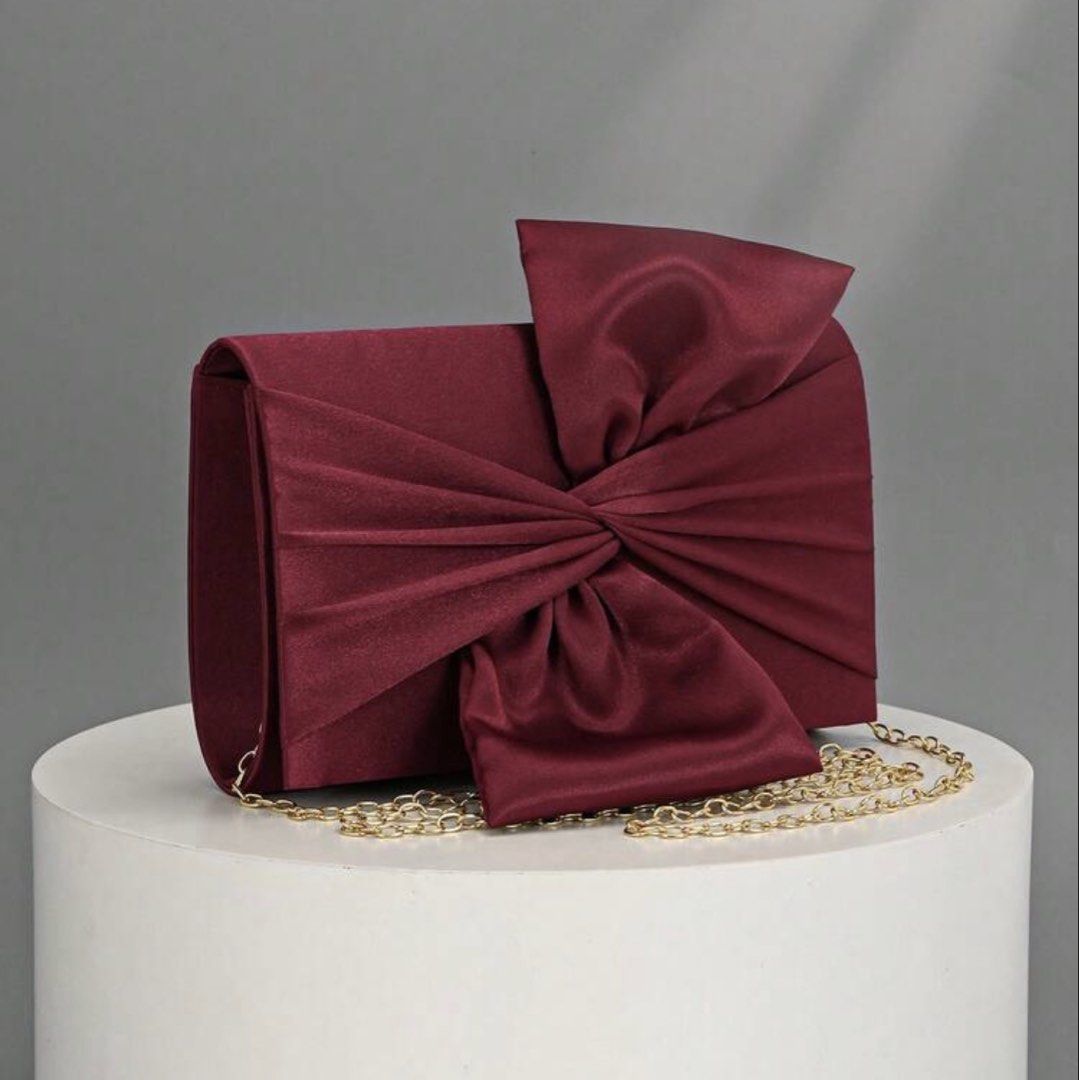 Maroon Satin Clutch with Bow Detail (Category: Clutches) located in Taguig. Submitted by aikaintongva (Listing ID 1439788604, Image 1). Description: - Elegant maroon satin clutch - Features a decorative bow - Includes a gold chain strap - Rectangular shape with flap closure - Perfect for special occasions - Luxurious satin material.