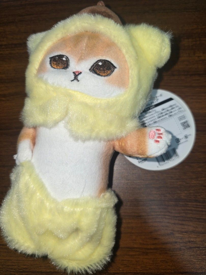Mofusand Cat Plush Toy x Sanrio (Category: Toys & Games) located in Manila. Submitted by nammie968 (Listing ID 1439637066, Image 1). Description: - Adorable Mofusand cat plush toy - Features a cute cat in a yellow outfit - Includes original tag - Soft and cuddly material - Detailed embroidery - Comes with a small keychain - Perfect for collectors or gifting.