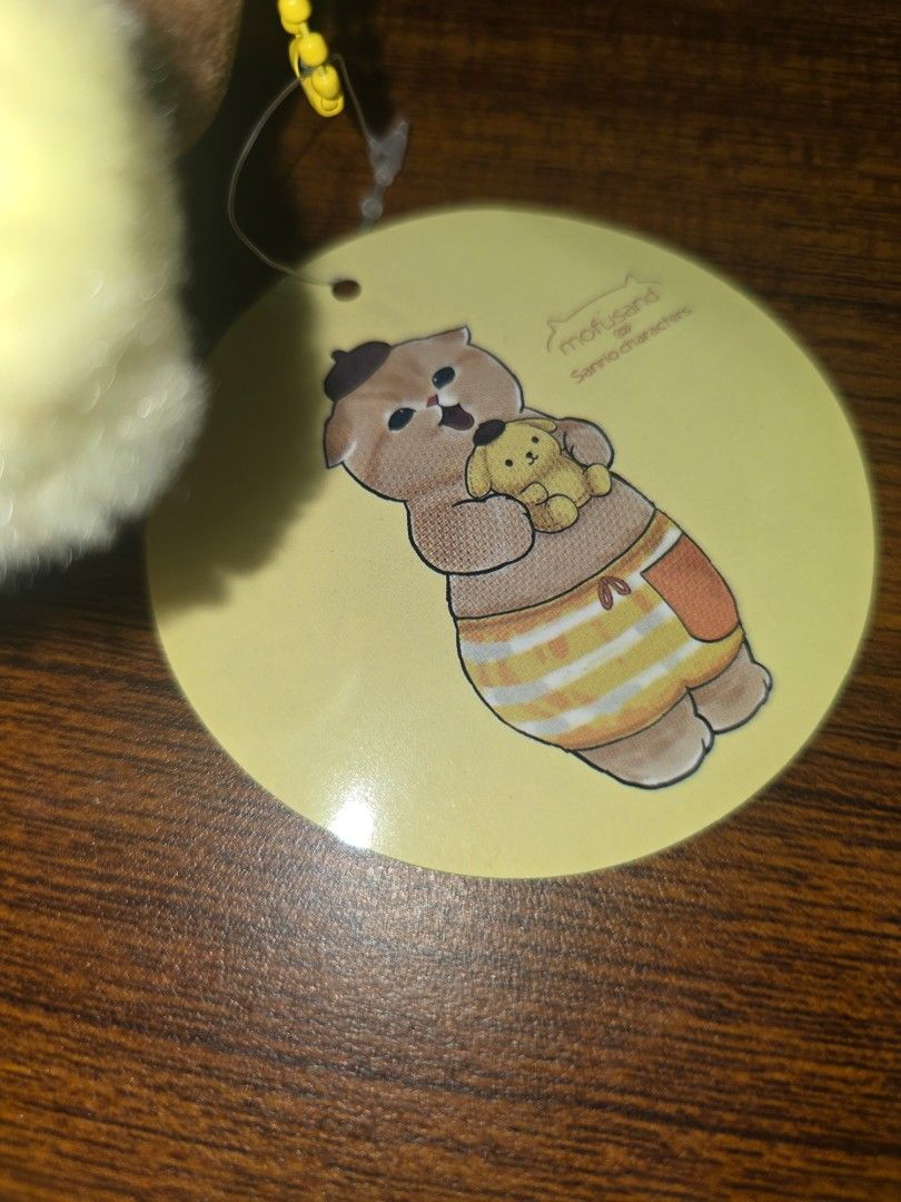 Mofusand Cat Plush Toy x Sanrio (Category: Toys & Games) located in Manila. Submitted by nammie968 (Listing ID 1439637066, Image 3). Description: - Adorable Mofusand cat plush toy - Features a cute cat in a yellow outfit - Includes original tag - Soft and cuddly material - Detailed embroidery - Comes with a small keychain - Perfect for collectors or gifting.