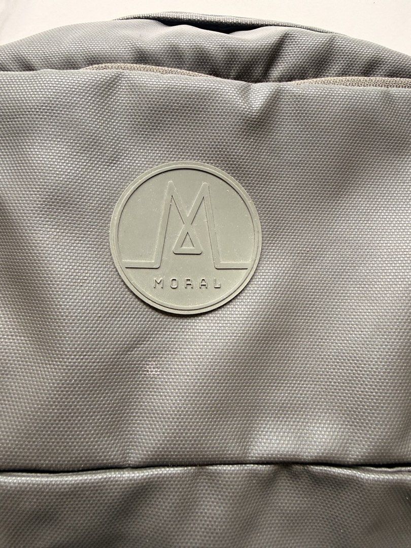 Moral Backpack （分類：背包）位於 Hong Kong。 由 cheesesmith 提交（商品編號 1439626940，圖片 2）。簡介： Durable Moral backpack in a dark grey color. Features a main compartment, front pocket, and side pockets. The backpack has padded shoulder straps and a top handle for easy carrying. The Moral logo is visible on the front and back of the backpack. Zippers are present on the main and side compartments. Well used and letting go for a good price. See pictures for condition