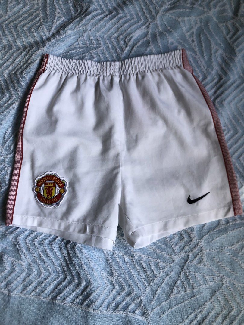 Nike Manchester United Shorts (Category: Babies & Kids Fashion) located in Aliaga. Submitted by imang_13 (Listing ID 1439687904, Image 1). Description: ✅like new ✅3-4yo ✅unisex White shorts with red stripes on the sides. Features the Manchester United logo and a Nike logo. The shorts are made in Thailand. The size is 28-36MOS / 90-98 cm..