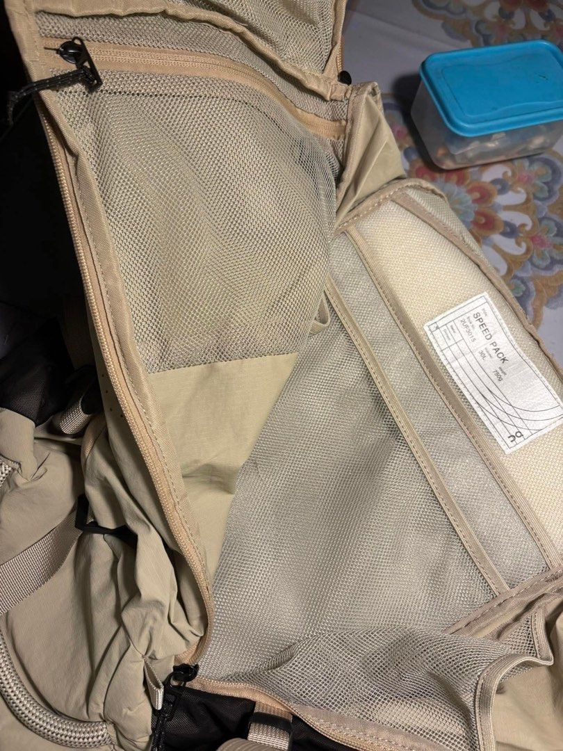 On Cloud Speed Pack 30L Backpack (Category: Backpacks) located in Makati City. Submitted by ellope (Listing ID 1439651504, Image 3). Description: On Cloud Speed Pack 30L backpack in beiges. Features multiple straps, compartments, and a mesh back panel for breathability. Includes internal pockets, top zipper closure, and adjustable straps. Speed Pack model label inside..