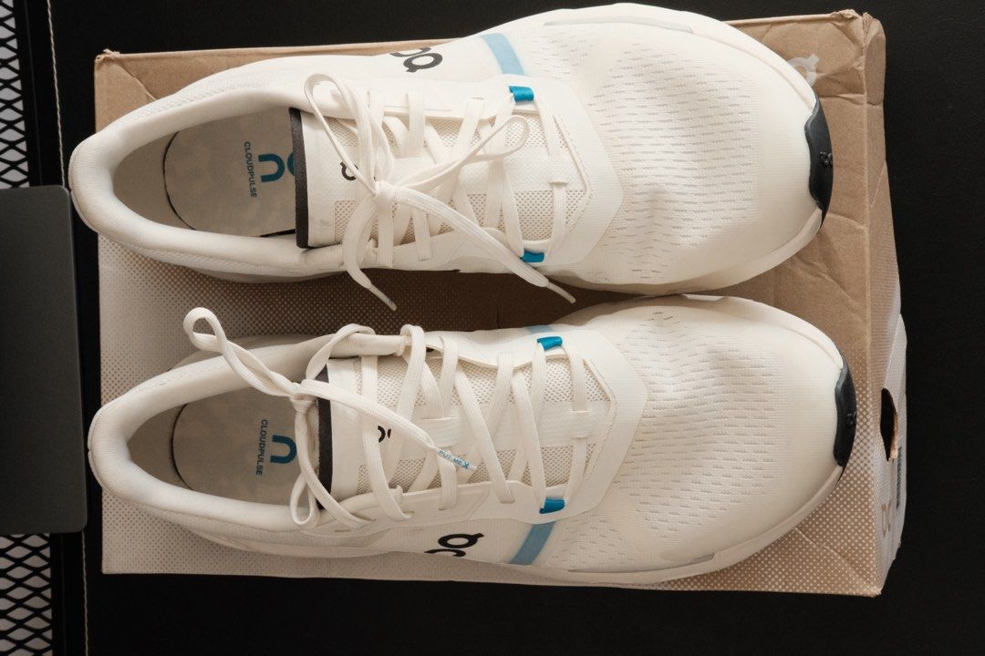 On Cloudpulse (Category: Sneakers) located in Kuala Lumpur. Submitted by hadibass (Listing ID 1439656065, Image 2). Description: - On Cloudpulse running shoes - White color with blue accents - Size: 10.5 US men's - CloudTec sole for superior cushioning - Includes original box - Features white laces - On logo visible on the side - Sole color: Black and grey.