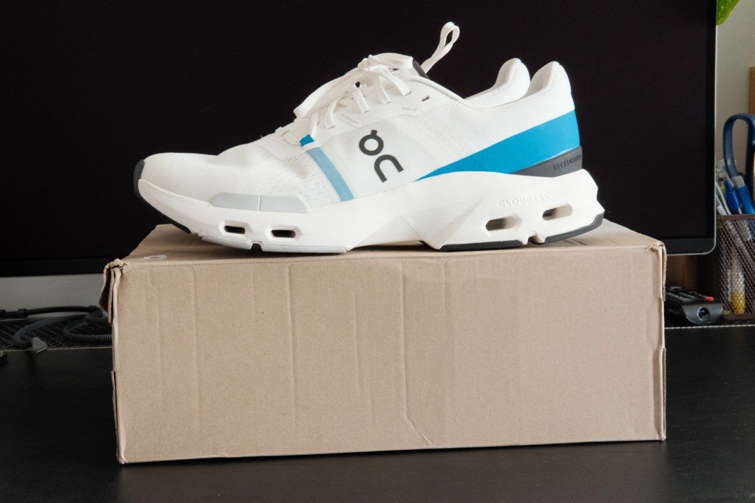 On Cloudpulse (Category: Sneakers) located in Kuala Lumpur. Submitted by hadibass (Listing ID 1439656065, Image 3). Description: - On Cloudpulse running shoes - White color with blue accents - Size: 10.5 US men's - CloudTec sole for superior cushioning - Includes original box - Features white laces - On logo visible on the side - Sole color: Black and grey.