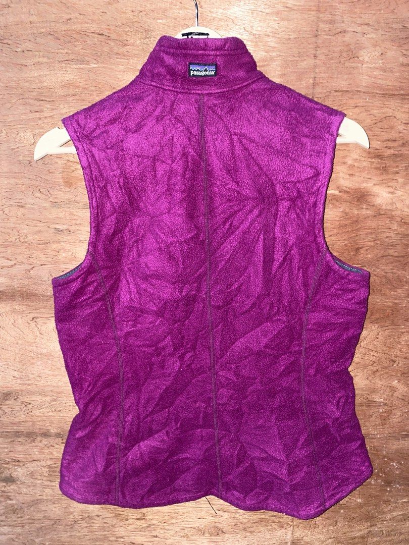 Patagonia Fleece Vest (Category: Others Tops) located in Puerto Princesa. Submitted by earlpogitrhift (Listing ID 1439608257, Image 2). Description: Patagonia fleece vest features a full zip closure and two zippered pockets. It has a high collar and a purple exterior with grey accents. The Patagonia logo is visible on the back of the collar..