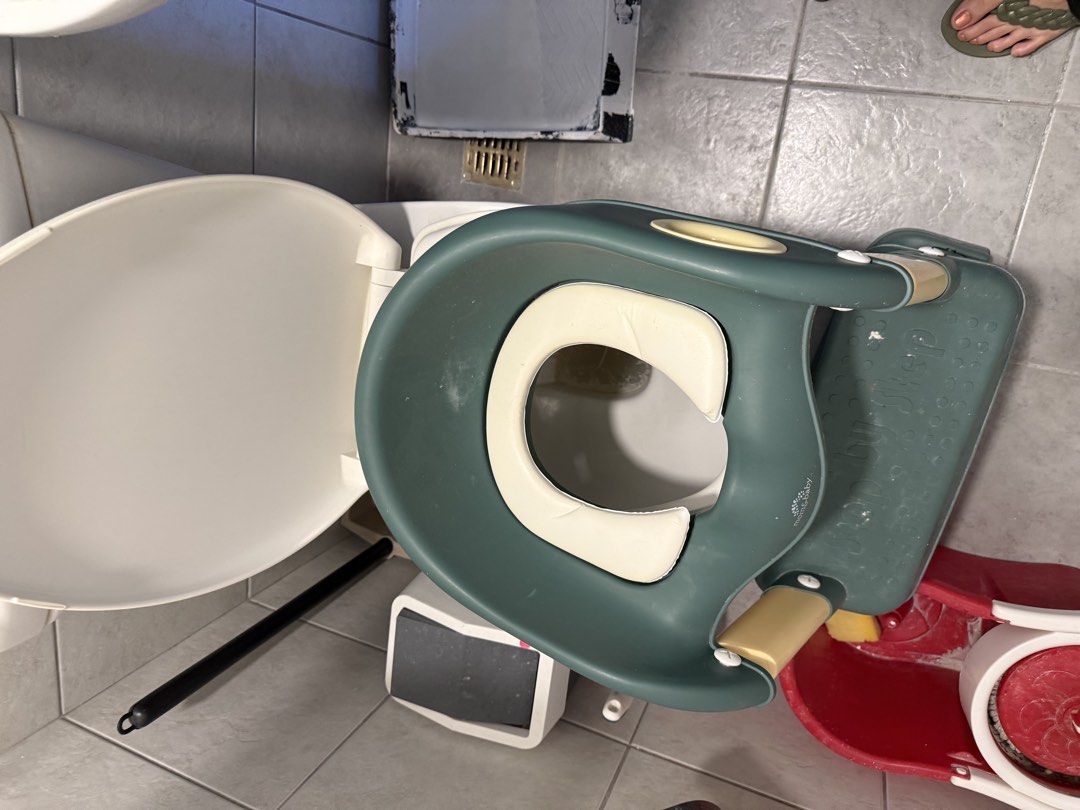 Potty Training Toilet Seat (Category: Toilet Training) located in Makati City. Submitted by rockandraw (Listing ID 1439741443, Image 1). Description: - Fits standard toilets - Green seat with white cushion - Features handles for security - Helps with potty training.