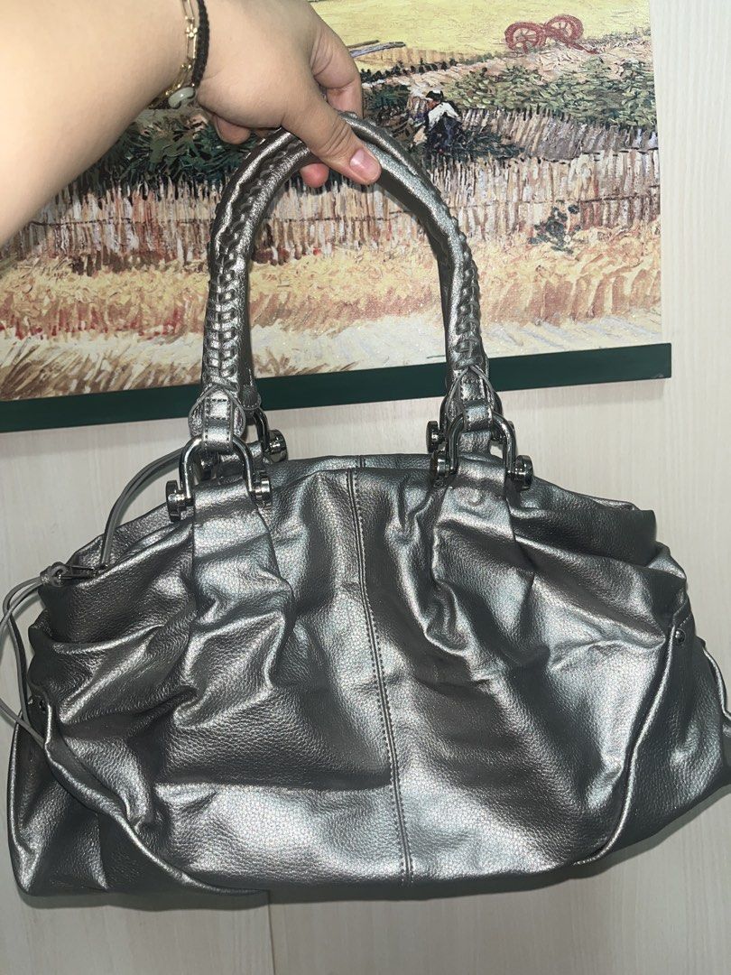 Silver Handbag with Braided Handles (Category: Luxury Bags & Wallets) located in Quezon City. Submitted by edmrubi (Listing ID 1439719820, Image 1). Description: - Silver handbag - Braided handles - Zippered main compartment - Multiple interior pockets - Textured exterior - Silver hardware - Top handle and shoulder strap - Gray interior lining - Drawstring detail on sides.