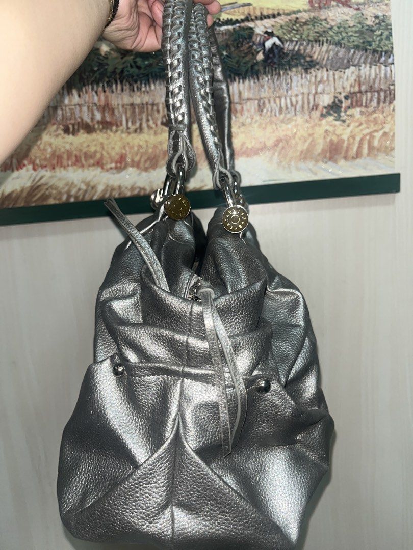 Silver Handbag with Braided Handles (Category: Luxury Bags & Wallets) located in Quezon City. Submitted by edmrubi (Listing ID 1439719820, Image 2). Description: - Silver handbag - Braided handles - Zippered main compartment - Multiple interior pockets - Textured exterior - Silver hardware - Top handle and shoulder strap - Gray interior lining - Drawstring detail on sides.