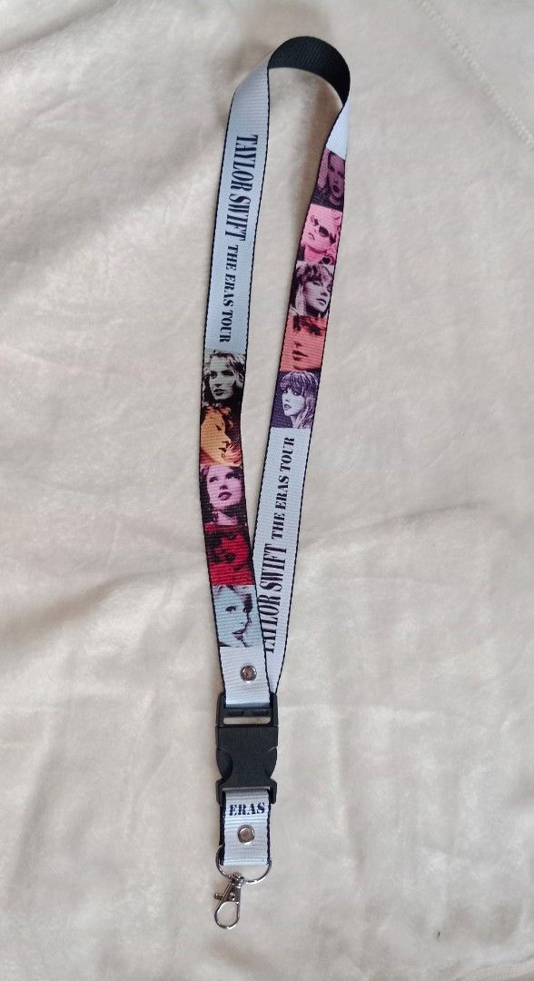 Taylor Swift Eras Tour Lanyard (Category: Western Merchandise) located in Manila. Submitted by angeloarce64172 (Listing ID 1439619169, Image 1). Description: - Taylor Swift "The Eras Tour" lanyard - Features images of Taylor Swift - White lanyard with black text and images - Includes a black buckle and metal clip - Ideal for keys, IDs, and small items.