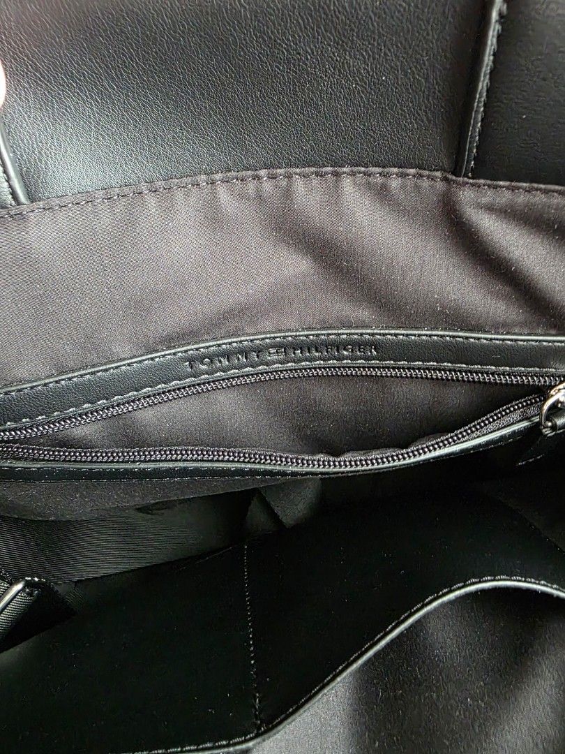 Tommy Hilfiger Black Tote Bag (Category: Tote Bags) located in Makati City. Submitted by chris_angle (Listing ID 1439621002, Image 3). Description: - Tommy Hilfiger black tote bag - Used 2x only - Structured design - Dual handles and detachable shoulder strap - Minimalist aesthetic - Subtle embossed details - Features strap with Tommy Hilfiger signature colors Dimensions: ● Width 34cm • Depth 12cm • Height 40cm • Minimum strap length 97cm • Maxim