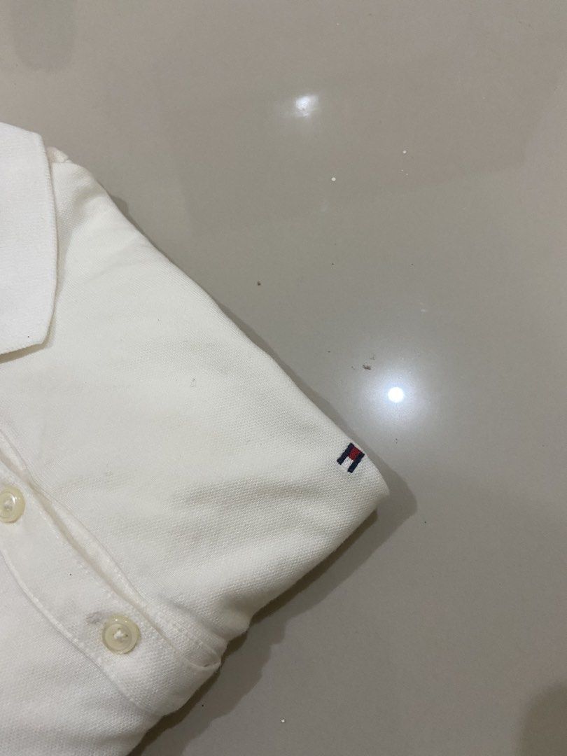 Tommy Hilfiger White Polo Shirt - Medium (Category: Tshirts & Polo Shirts ) located in Lapu Lapu. Submitted by trip-thrift (Listing ID 1439752791, Image 3). Description: - Tommy Hilfiger polo shirt - Size: M - Features the Tommy Hilfiger logo - Classic polo collar - Made in Vietnam - Short sleeves - Button-up front - Material: Cotton and Spandex blend.