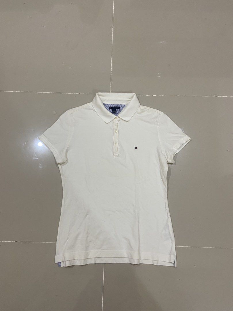 Tommy Hilfiger White Polo Shirt - Medium (Category: Tshirts & Polo Shirts ) located in Lapu Lapu. Submitted by trip-thrift (Listing ID 1439752791, Image 1). Description: - Tommy Hilfiger polo shirt - Size: M - Features the Tommy Hilfiger logo - Classic polo collar - Made in Vietnam - Short sleeves - Button-up front - Material: Cotton and Spandex blend.