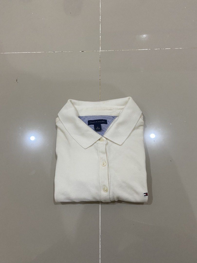 Tommy Hilfiger White Polo Shirt - Medium (Category: Tshirts & Polo Shirts ) located in Lapu Lapu. Submitted by trip-thrift (Listing ID 1439752791, Image 2). Description: - Tommy Hilfiger polo shirt - Size: M - Features the Tommy Hilfiger logo - Classic polo collar - Made in Vietnam - Short sleeves - Button-up front - Material: Cotton and Spandex blend.