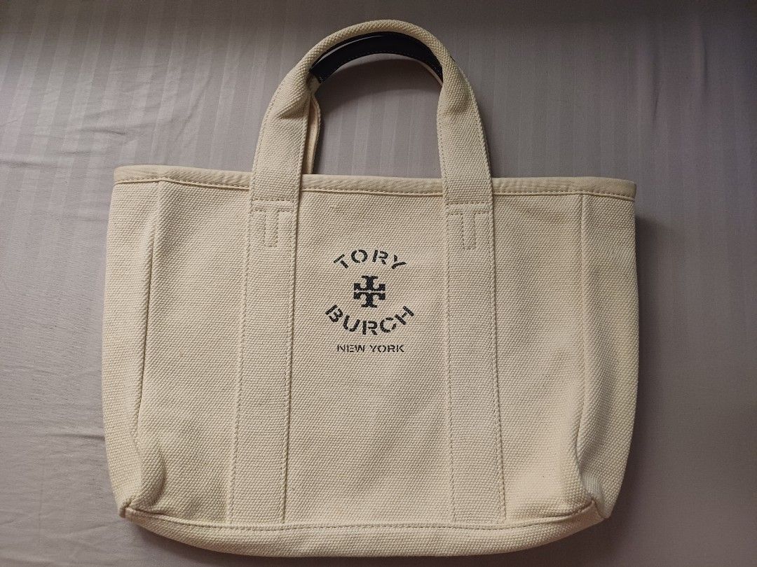 Tory Burch Canvas Tote Bag (Category: Luxury Bags & Wallets) located in Rizal. Submitted by raishin_listings (Listing ID 1439759444, Image 2). Description: - Authentic Tory Burch tote bag - Canvas exterior - Leather handles - Tory Burch logo on front - Minor yellowish stain inside - Black leather handles with white stitching - Perfect for everyday use.
