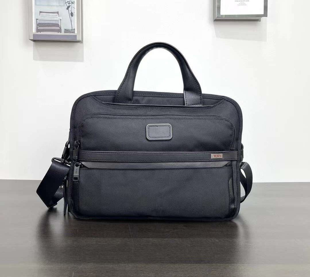 Tumi Alpha Bravo Triple Compartment Laptop Bag (Category: Briefcases) located in Manila. Submitted by bagmaniaph (Listing ID 1439784729, Image 1). Description: - Black Tumi briefcase - Top handle and detachable shoulder strap - Multiple zippered compartments - Durable, textured material - Tumi logo visible.