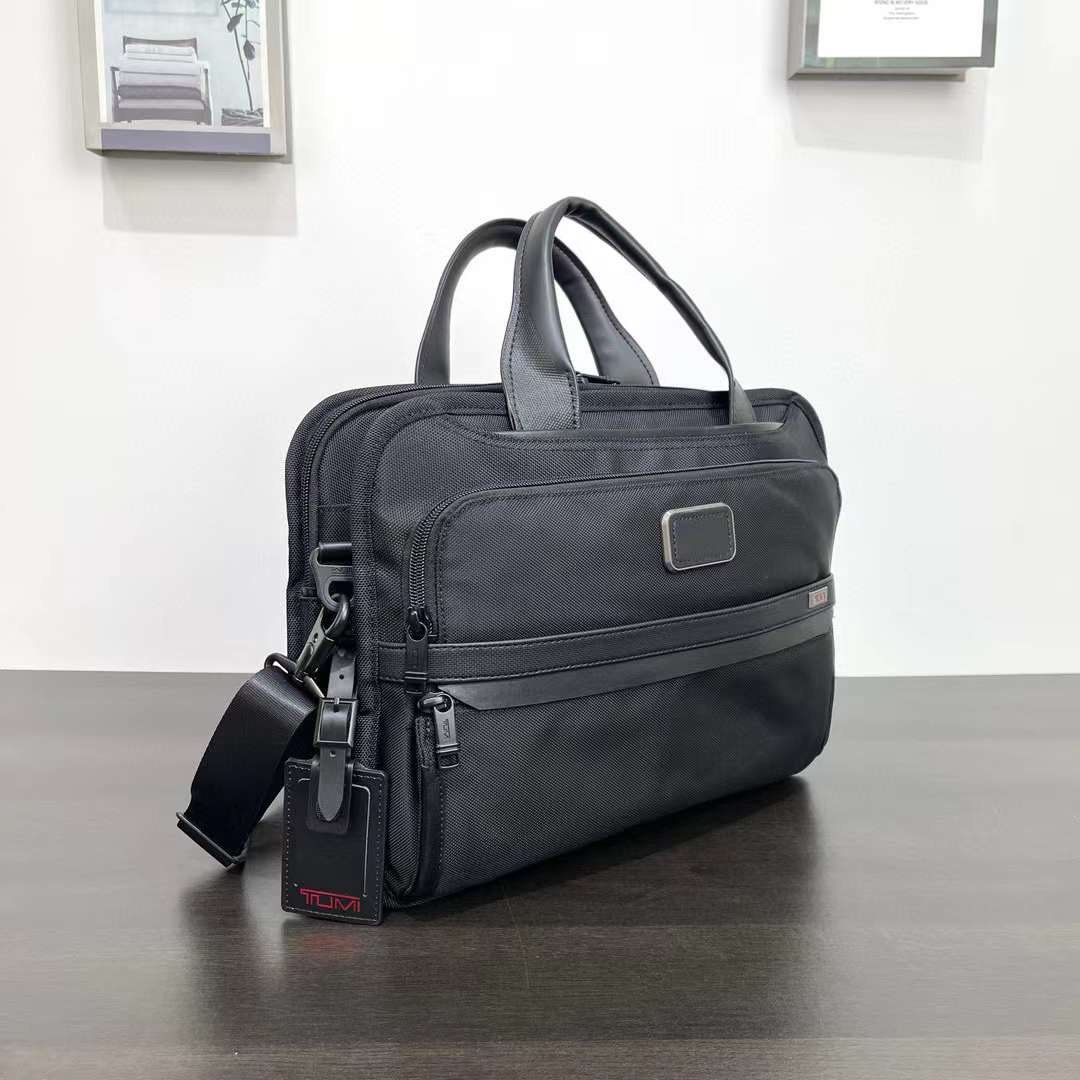 Tumi Alpha Bravo Triple Compartment Laptop Bag (Category: Briefcases) located in Manila. Submitted by bagmaniaph (Listing ID 1439784729, Image 2). Description: - Black Tumi briefcase - Top handle and detachable shoulder strap - Multiple zippered compartments - Durable, textured material - Tumi logo visible.