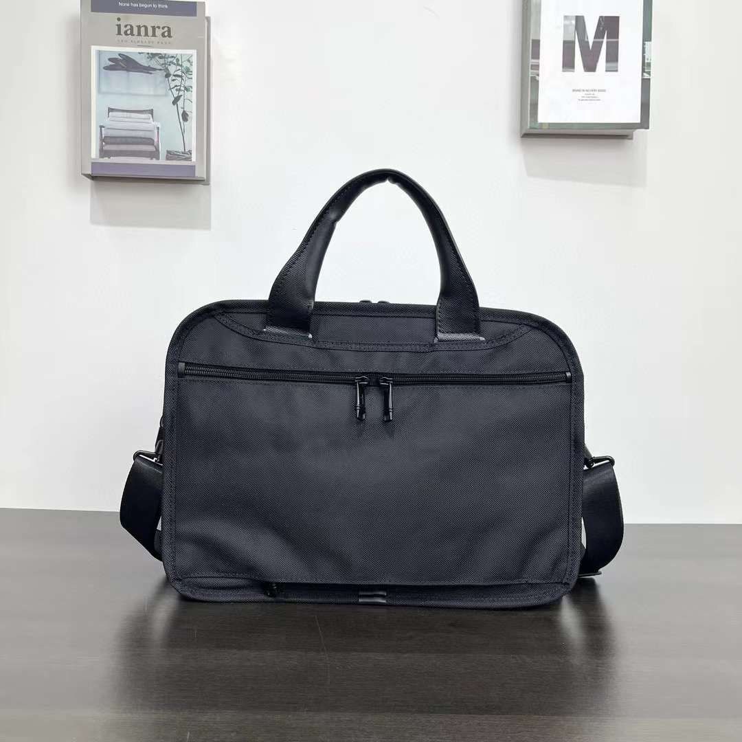 Tumi Alpha Bravo Triple Compartment Laptop Bag (Category: Briefcases) located in Manila. Submitted by bagmaniaph (Listing ID 1439784729, Image 3). Description: - Black Tumi briefcase - Top handle and detachable shoulder strap - Multiple zippered compartments - Durable, textured material - Tumi logo visible.