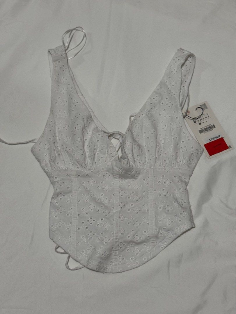 Zara White Eyelet Corset Tie-Back Top (Category: Sleeveless) located in Cavite. Submitted by ellieschoice (Listing ID 1439668924, Image 1). Description: For reference, I usually get xs sa zara pero hanggang small lang yung size for this top I have a similar white eyelet dress so I'm selling this na.