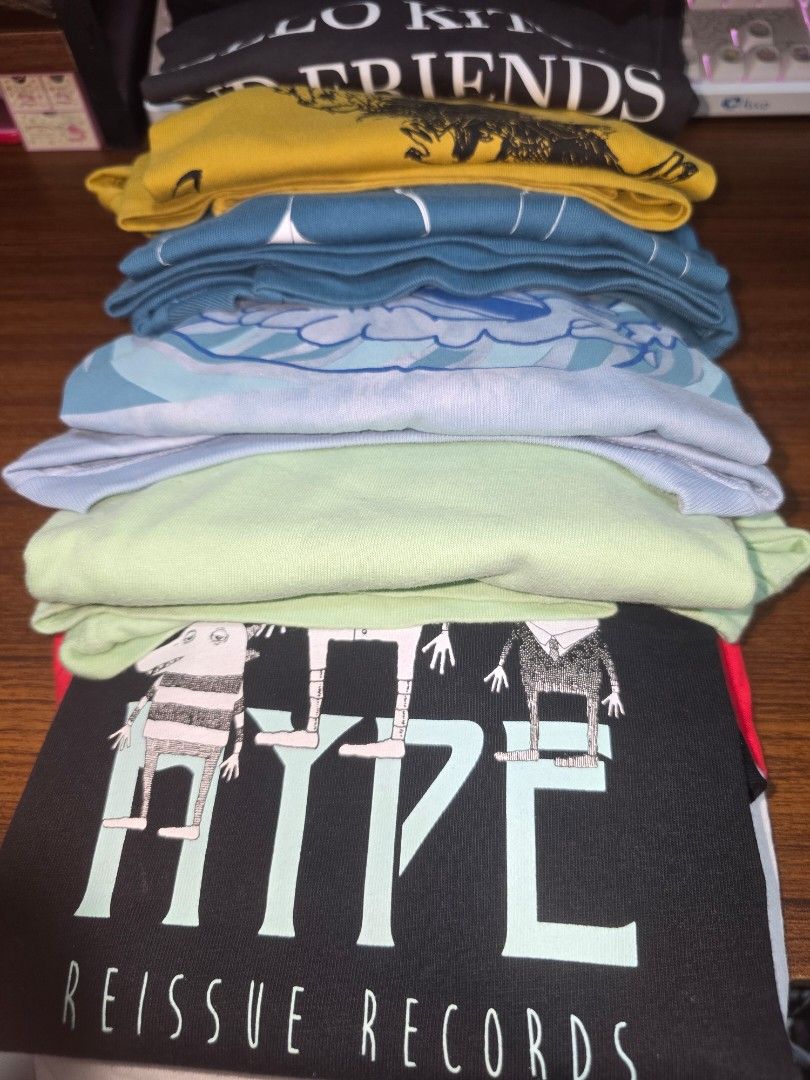 Assorted Graphic T-shirts Bundle (Category: Shirts) located in Manila. Submitted by nammie968 (Listing ID 1439918903, Image 1). Description: - Bundle of graphic t-shirts in various colors and designs. - Black t-shirt featuring 'RIFFLE REISSUE RECORDS' text and cartoon characters. - Yellow t-shirt with a unique graphic print. - Several blue and light blue t-shirts showcasing different patterns. - Includes a light green t-shirt. - Perfect for casua