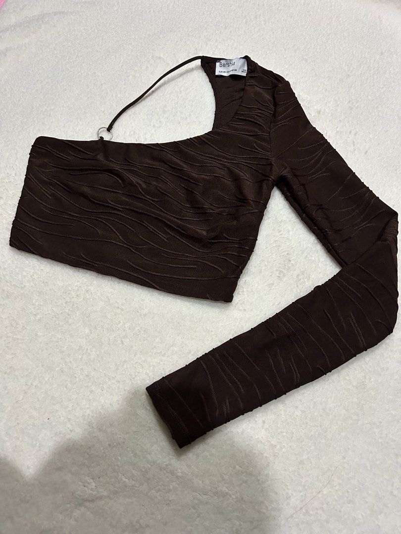 Bershka Brown One-Shoulder Ruched Crop Top (Category: Sleeveless) located in Bambang. Submitted by weeeyyaaa (Listing ID 1439930749, Image 2). Description: - Brand: Bershka - Color: Brown - Style: Crop Top - Design: One-shoulder, long sleeves - Details: Ruched all over, textured wavy pattern, metal ring accent on strap - Occasion: Night out, fashionable casual look.