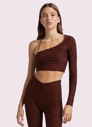 Bershka Brown One-Shoulder Ruched Crop Top (Category: Sleeveless) located in Bambang. Submitted by weeeyyaaa (Listing ID 1439930749, Image 1). Description: - Brand: Bershka - Color: Brown - Style: Crop Top - Design: One-shoulder, long sleeves - Details: Ruched all over, textured wavy pattern, metal ring accent on strap - Occasion: Night out, fashionable casual look.