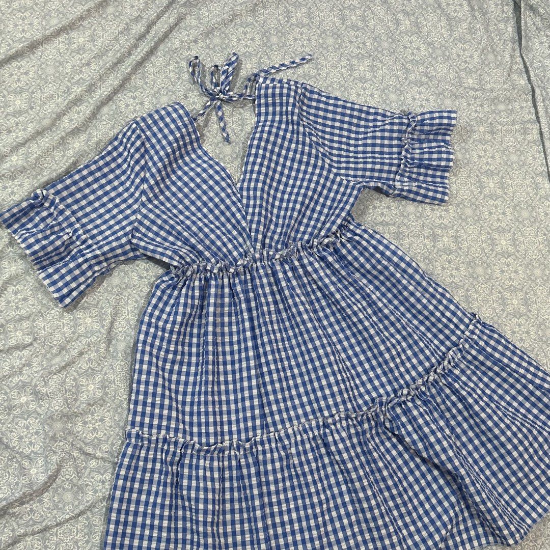 Blue Gingham Dress (Category: Dresses) located in Quezon City. Submitted by fishballer9000 (Listing ID 1439847383, Image 1). Description: Blue and white gingham patterned summer dress ! 🌀🤍 size: best fits M-L - V-neckline - Short sleeves with ruffled edges - Tiered skirt - Tie detail at back - Lightweight fabric - Ideal for warm weather.