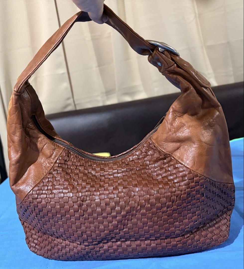 Brown Woven Leather Shoulder Bag (Category: Shoulder Bags) located in Manila. Submitted by truedeclutter (Listing ID 1439860884, Image 2). Description: - Stylish brown shoulder bag - Woven leather design - Comfortable shoulder strap with silver-tone buckle - Secure zipper closure - Made of beautiful genuine leather - Dimensions: Approximately 15" height x 8" width.