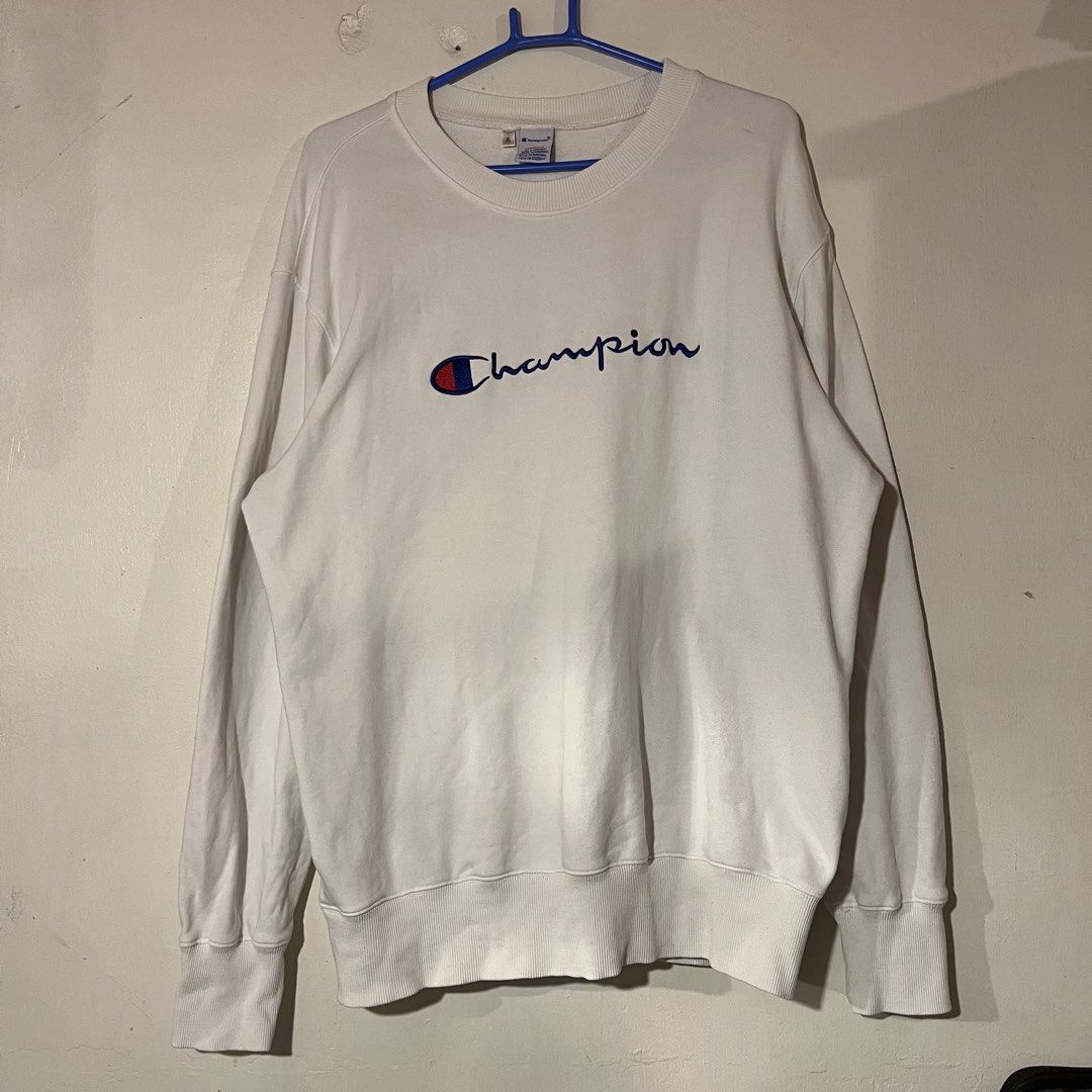 Champion | White Sweatshirt (Category: Coats, Jackets and Outerwear) located in Quezon City. Submitted by giometryyy (Listing ID 1439985071, Image 1). Description: L28 W22 XL on tag best fit L excellent condition already washed embroidered spell out 📍East Fairview, QC 🛵Lalamove / J&T payment first.