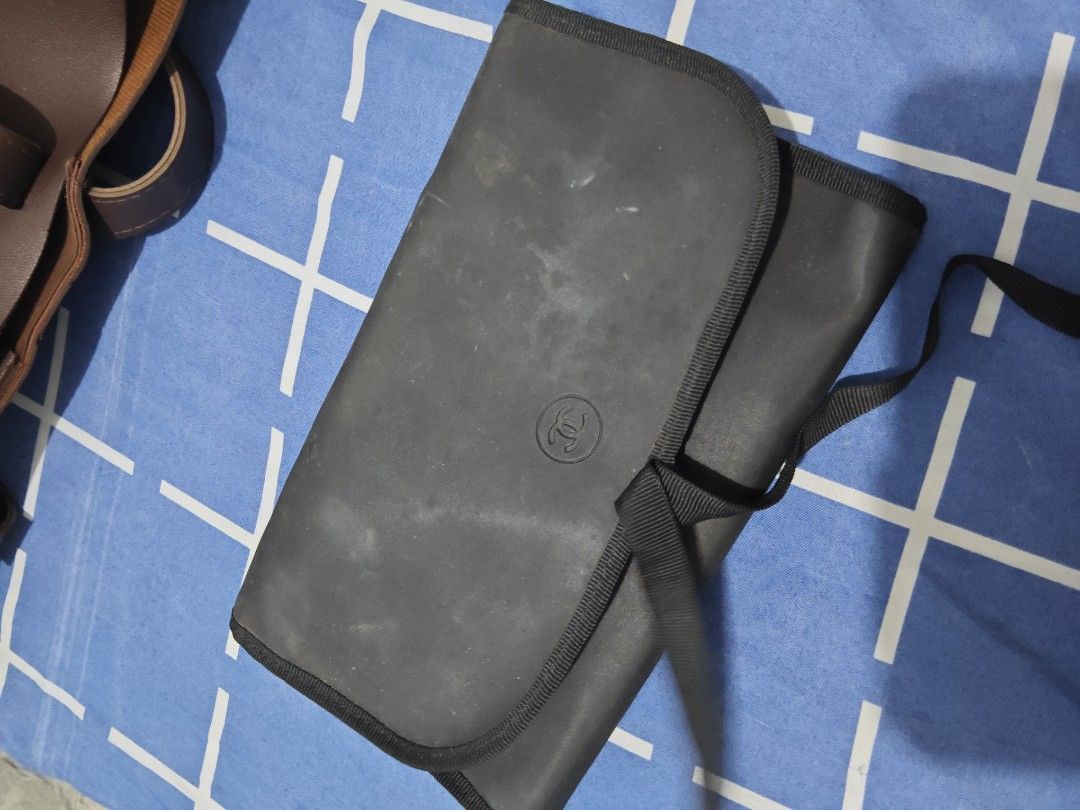 Chanel Black Makeup Brush Organizer Pouch with Straps (Category: Makeup) located in Batangas. Submitted by fendi.closet (Listing ID 1439980586, Image 1). Description: - Black makeup brush organizer pouch - Multiple slots for secure brush storage - Zippered compartment for small items - Folds closed and secures with a strap - Ideal for travel or everyday storage - Dedicated spaces for various brush sizes needs cleaning .