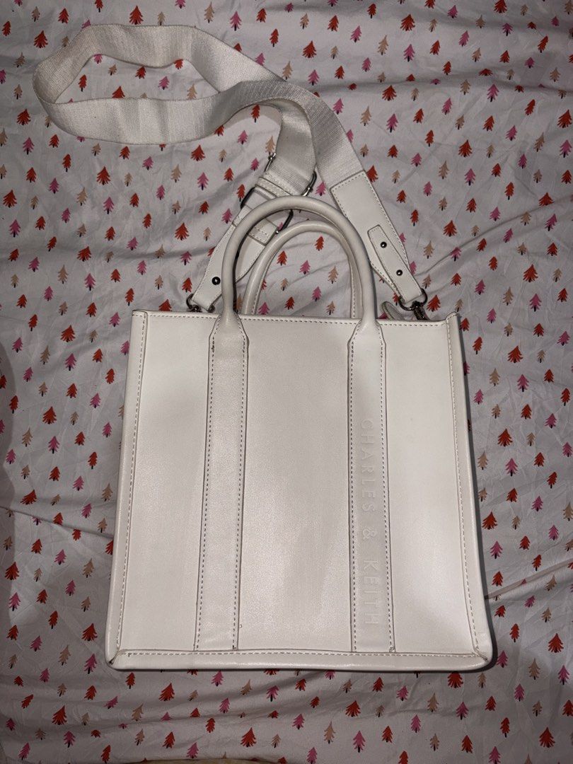 Charles & Keith White Tote Bag with Pouch (Category: Tote Bags) located in Manila. Submitted by fierce_denclutter (Listing ID 1439939209, Image 1). Description: - Stylish white Charles & Keith tote bag - Subtle embossed brand name on the side - Comes with a matching zippered pouch - Spacious, lined interior - Detachable shoulder strap for versatile carrying.