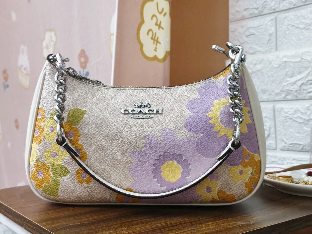 Coach Teri (Category: Luxury Bags & Wallets) located in Ormoc. Submitted by jonaprelove (Listing ID 1439840887, Image 3). Description: - Coach shoulder bag - Beautiful floral print design - Includes chain strap and adjustable strap - Beige base with colorful floral accents - White side panels - Coach logo on front - Stylish and versatile.