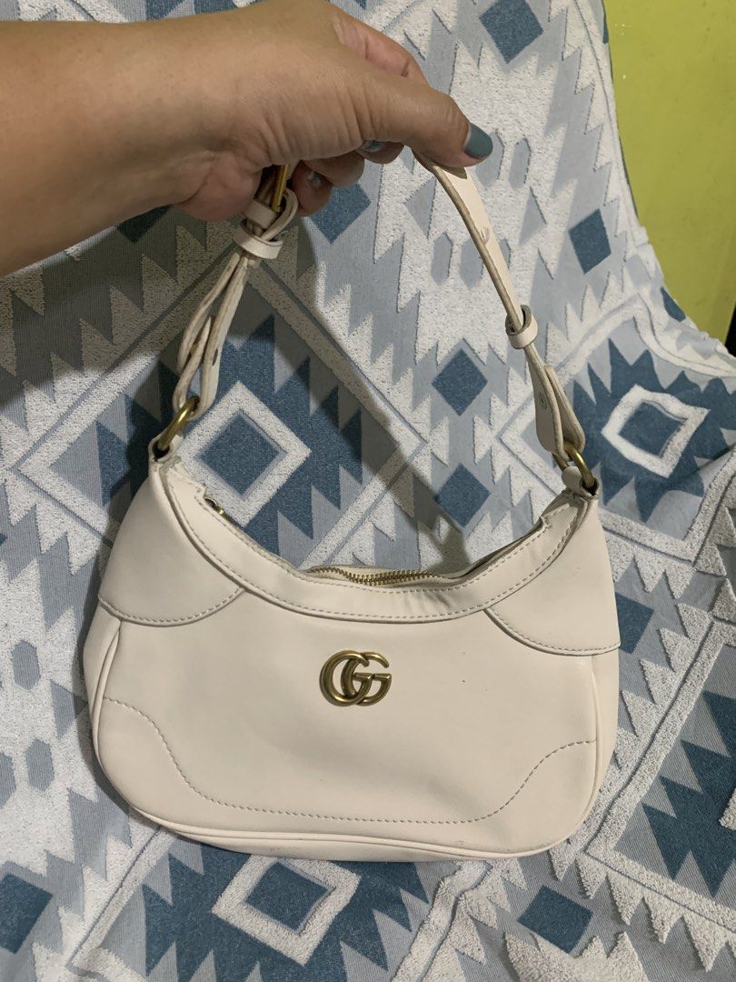 Cream Shoulder Bag with GG Logo (Category: Luxury Bags & Wallets) located in Liloan. Submitted by jinalyns (Listing ID 1439964305, Image 1). Description: - Stylish cream shoulder bag - Features prominent gold-tone GG logo - Zippered main compartment - Comfortable, adjustable shoulder strap - Lined interior with a small pocket - Versatile for everyday or evening wear.