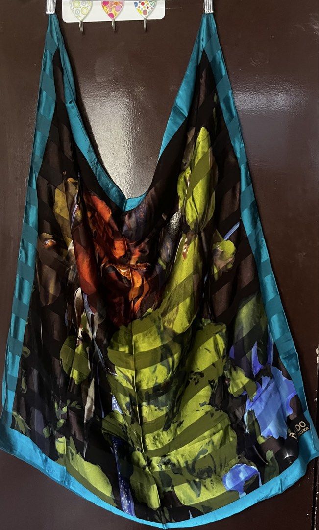 Designer Floral Print Silk Scarf (Category: Scarves) located in Cebu City. Submitted by 7paws (Listing ID 1439984220, Image 3). Description: - Beautiful and vibrant silk scarf - Striking floral print with bold colors (lime green, deep blue, orange, brown) - Dark background with subtle striped detailing - Contrasting turquoise trim on edges - Perfect accessory to add elegance to any outfit.