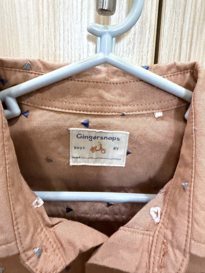 Gingersnaps Boys Shirt 8Y (Category: Babies & Kids Fashion) located in San Juan City. Submitted by addieandmatty (Listing ID 1439850048, Image 2). Description: - Gingersnaps boys' shirt - Size: 8Y - Design: Button-down, long sleeves - Color: Light brown - Pattern: Small blue and white triangles - Neckline: Collared - Fit: Classic.