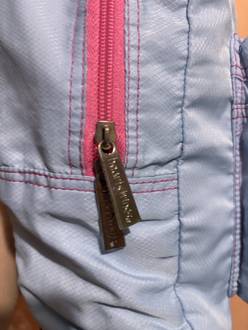 Heartstrings Blue Backpack (Category: Backpacks) located in San Fernando. Submitted by ladychinita07 (Listing ID 1439814959, Image 3). Description: - Light blue Heartstrings backpack - Pink zippers and stitching - Front pocket - Adjustable straps - Brand name on front - Brand name engraved on zippers - Straps show wear.