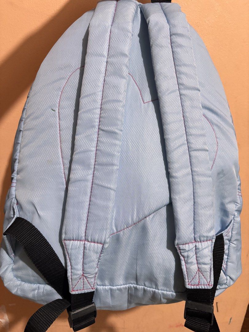 Heartstrings Blue Backpack (Category: Backpacks) located in San Fernando. Submitted by ladychinita07 (Listing ID 1439814959, Image 2). Description: - Light blue Heartstrings backpack - Pink zippers and stitching - Front pocket - Adjustable straps - Brand name on front - Brand name engraved on zippers - Straps show wear.