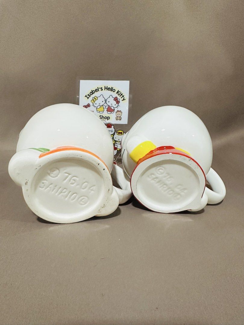 Hello Kitty Ceramic Mugs Set (Category: Coffee & Tea Tableware) located in Angeles City. Submitted by IsaCRSL (Listing ID 1439842760, Image 3). Description: - Adorable set of 2 Kitty ceramic mugs. - Features Kitty in two unique outfits. - Authentic Sanrio product (marked '76, '04). - Perfect for collectors. - Great for coffee, tea, or any beverage..
