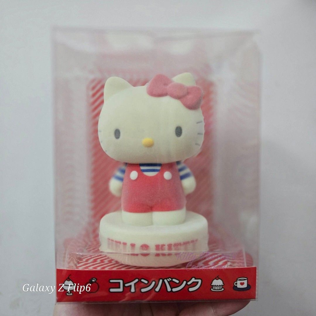 Hello Kitty Coin Bank with Red Overalls (Category: Character Goods) located in Manila. Submitted by vheronelunio24 (Listing ID 1439981845, Image 1). Description: - Adorable Kitty coin bank - Brand new in original packaging - Kitty wears classic red overalls and striped shirt - White base with embossed ' Kitty' logo - Ideal for collectors or as a charming gift - Encourages saving money in a fun way.