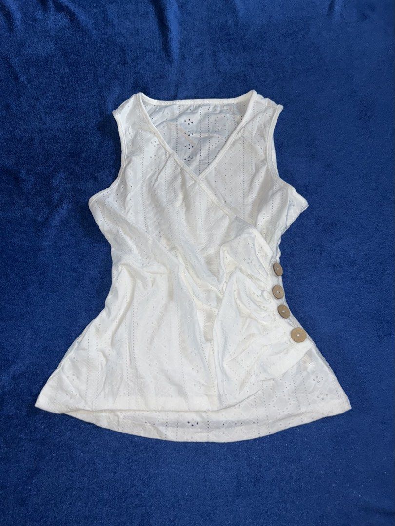 L White Eyelet Lace Faux-Wrap Button Top (Category: Sleeveless) located in Manila. Submitted by declutter_lala (Listing ID 1439952988, Image 1). Description: !!!PLEASE READ!!! White Eyelet Lace Faux-Wrap Button Top ✨Eyelet fabric ✨ V-neckline with faux-wrap drape over the front ✨ Side-gathering detail with wooden buttons L ON TAG ₱140.