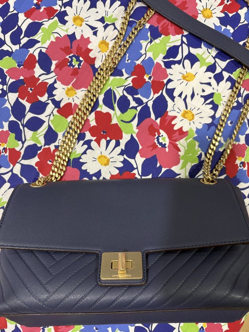 Louis Quatorze Navy Blue Shoulder Bag (Category: Shoulder Bags) located in Muntinlupa City. Submitted by rmsalberto (Listing ID 1439848140, Image 1). Description: Navy blue shoulder bag from Louis Quatorze. Features a gold-tone chain strap and a flap closure with a gold-tone clasp. The bag has a quilted design on the front and a slip pocket on the back. The interior has a zippered pocket. The brand name is visible on the clasp and the back of the