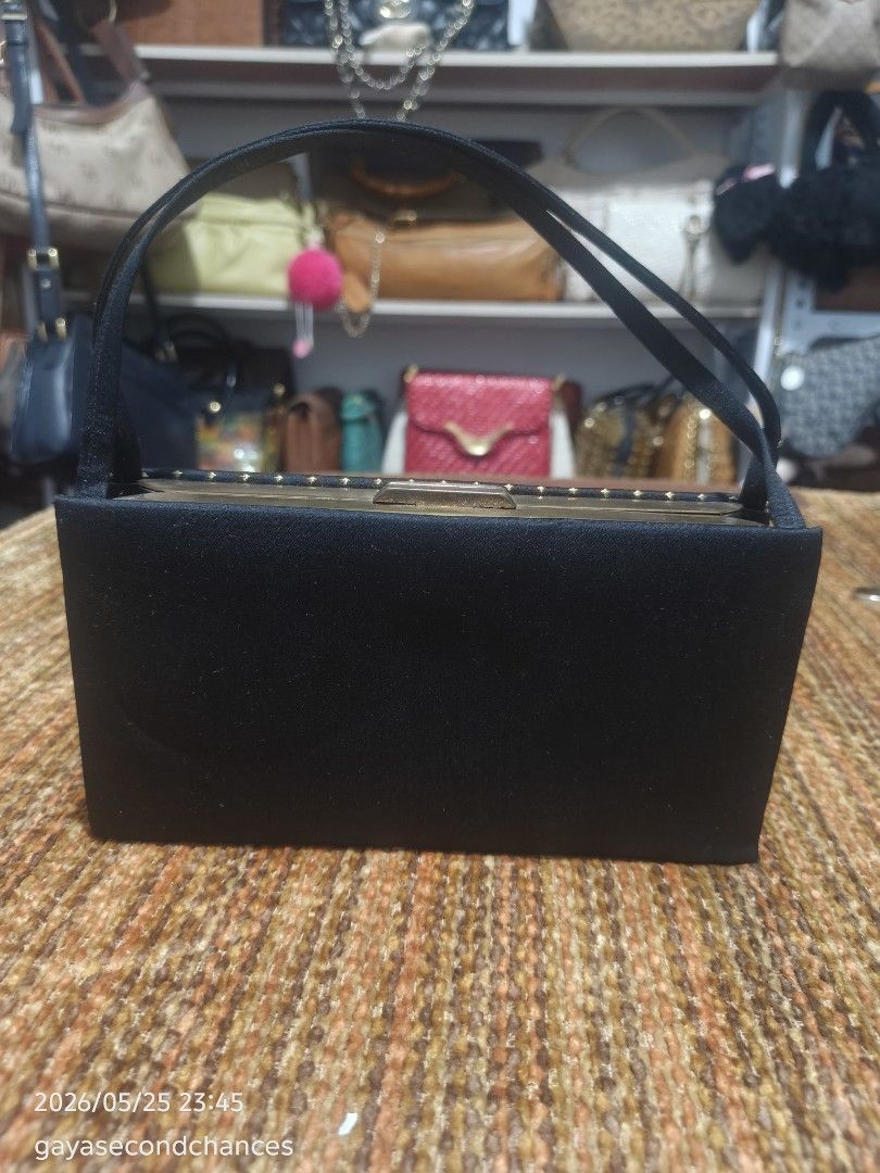 MAKE UP BAG (Category: Clutches) located in Kalibo. Submitted by secondchances.thriftsh8p (Listing ID 1439977709, Image 2). Description: - Elegant black clutch bag - Charming gold polka dot pattern - Structured rectangular shape - Secure clasp closure - Short, sleek handles for easy carrying - Perfect for evening events or adding sophistication.