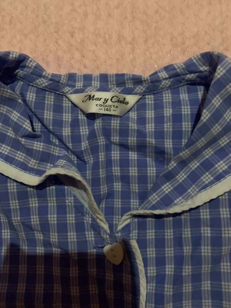 Mary y Cielo Blue Gingham Peplum Top (Category: Sleeveless) located in San Nicolas. Submitted by bissouluv (Listing ID 1439946381, Image 2). Description: - Charming blue gingham peplum top - Features a white Peter Pan collar - Button-down front - Short flutter sleeves - Flattering flared hemline - Perfect for a cute and playful look.