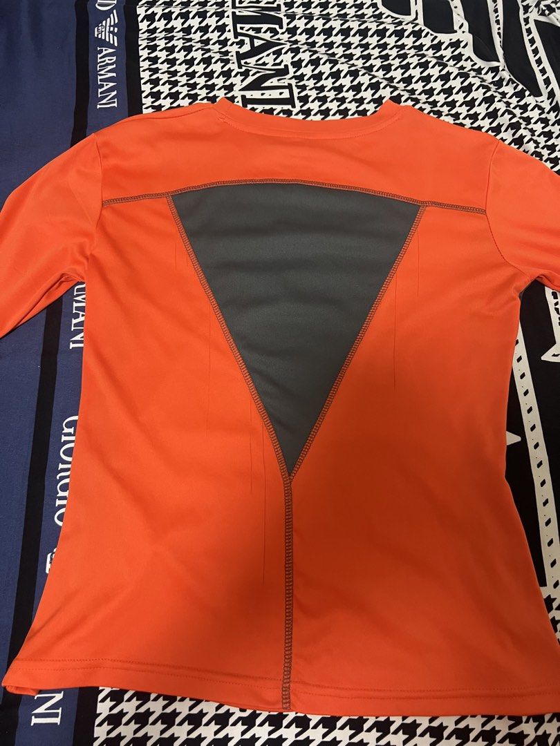 Nike Orange Long Sleeve Athletic Shirt (Category: Tshirts & Polo Shirts ) located in Manila. Submitted by oddcat.ac8a4a (Listing ID 1439947694, Image 2). Description: Vibrant orange Nike long-sleeved athletic shirt with black swoosh. Features dark grey side panels and a V-shaped back panel for breathability. Dark grey stitching..
