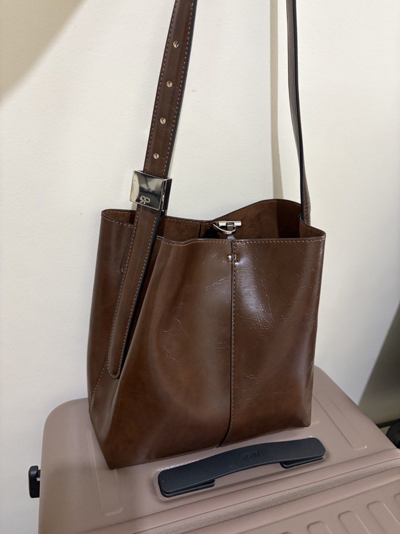 Parfois Shoulder Bag (Category: Shoulder Bags) located in Quezon City. Submitted by ppucco (Listing ID 1439887694, Image 1). Description: - Brown shoulder bag - Rectangular silver buckle - Main compartment and inner pouch - Adjustable strap - Smooth, leather-like material - Different interior texture.