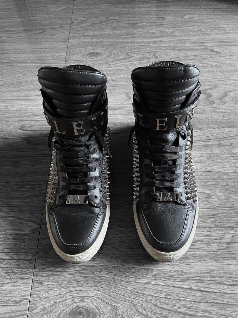 Philipp Plein ERNIE Studded High-Top Sneakers (Category: Sneakers & Footwear) located in Bulacan. Submitted by curated_2000 (Listing ID 1439979571, Image 2). Description: Crafted from premium black leather, this pair features full metal spike panels along the sides, oversized padded tongue and collar for a bulky silhouette, and the signature velcro ankle strap with silver “PLEIN” hardware lettering. Finished with skull lace hardware, tonal black 