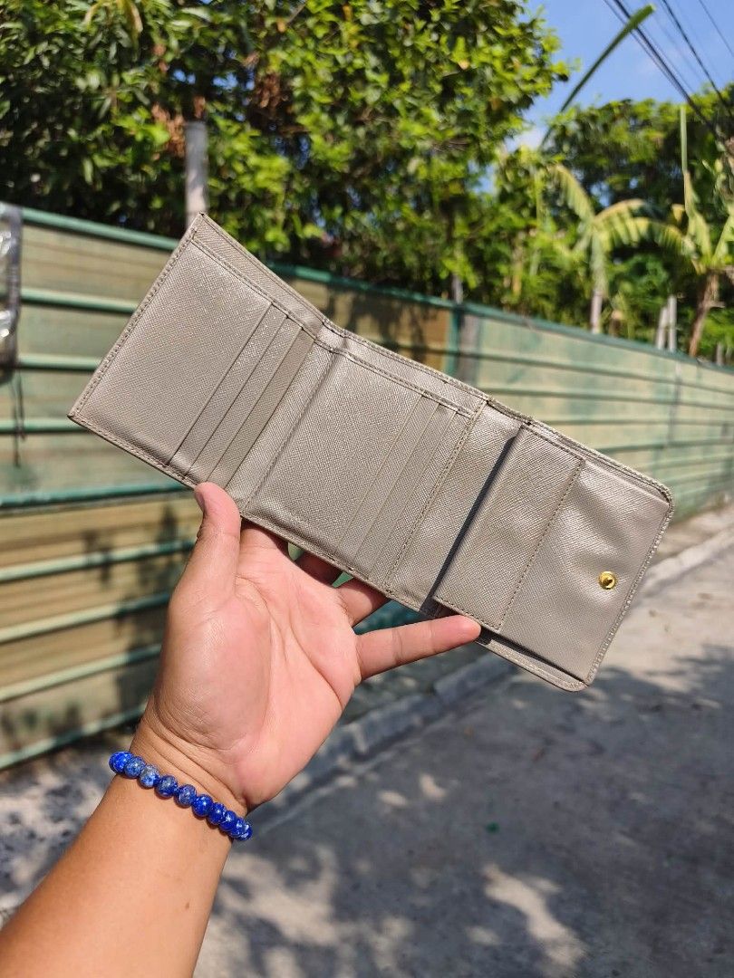 Prada Saffiano Trifold Wallet (Category: Luxury Bags & Wallets) located in Quezon City. Submitted by bybelaching (Listing ID 1439968456, Image 2). Description: - Authentic Prada Saffiano trifold wallet - Neutral grey color - Iconic Prada Milano logo on front - Multiple interior card slots and compartments - Classic and elegant for everyday use 8k + SF 😊.